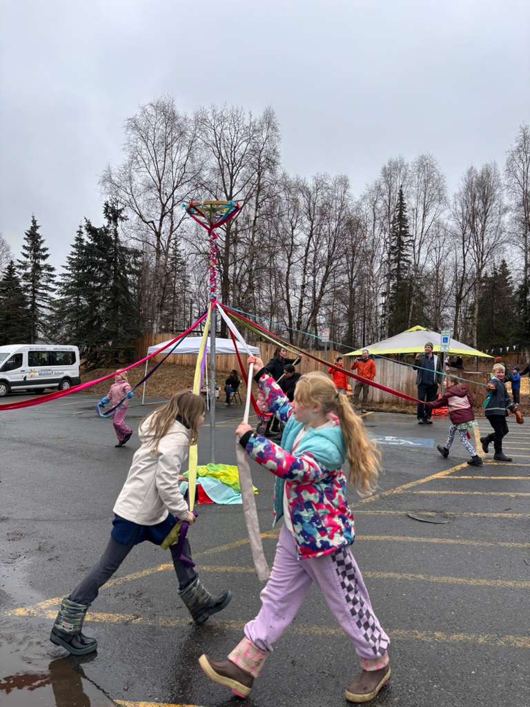 Anchorage Waldorf Students running around a may pole at the may faire