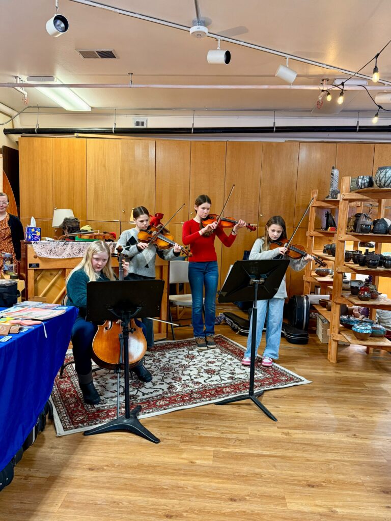 Anchorage waldorf school students playing string instruments at the winter faire